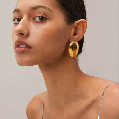 Woman wearing 18K gold-plated stainless steel teardrop stud earrings
