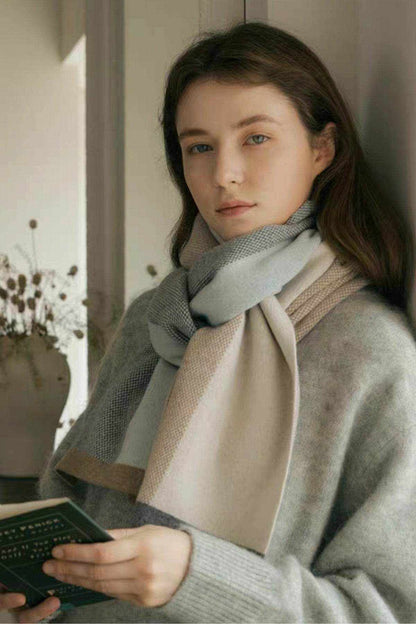Woman wearing thermal contrast acrylic scarf in neutral colors with gray sweater indoors
