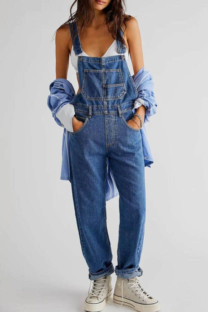 Woman wearing wide strap square neck denim overalls with pockets and crisscross back detailing