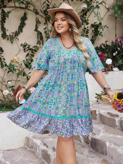 Plus size ruffled hem dress with lace detail and printed pattern, half sleeves, worn with a hat in garden setting