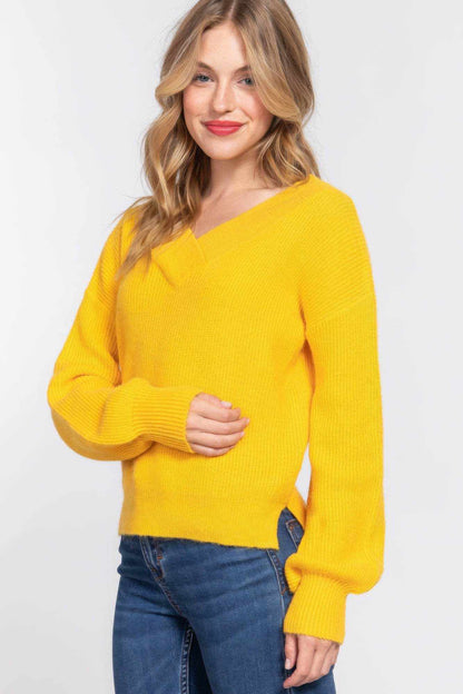 Yellow long sleeve double V-neck sweater with relaxed fit and ribbed cuffs worn by smiling woman