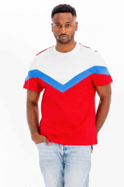 Man wearing a red, white, and blue color block t-shirt paired with light blue jeans