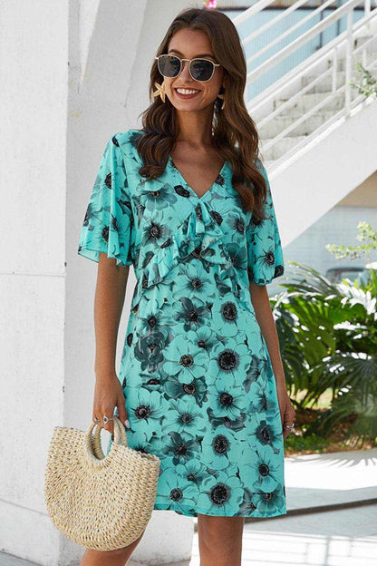 Woman wearing Ivy Lane backless ruffled printed V-neck dress in turquoise floral pattern outdoors
