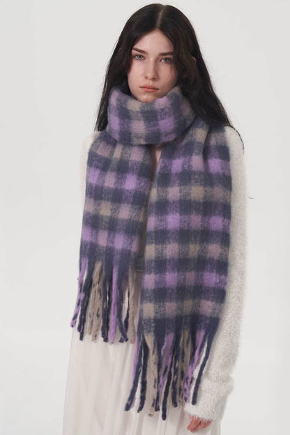 Woman wearing a purple and gray fringe plaid polyester scarf wrapped around her neck